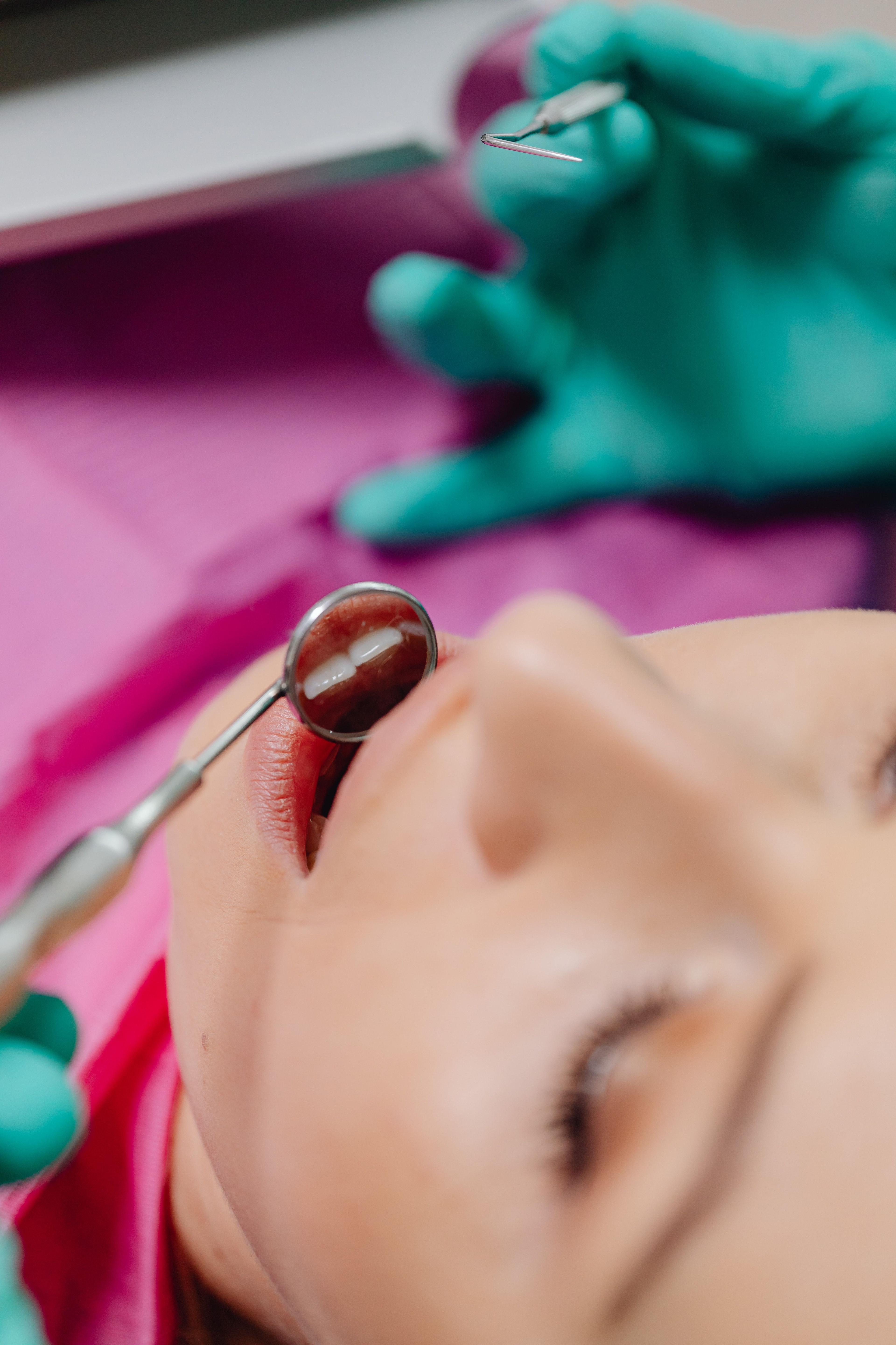 Behandler arbejder i en patients mund med spejl og instrument.