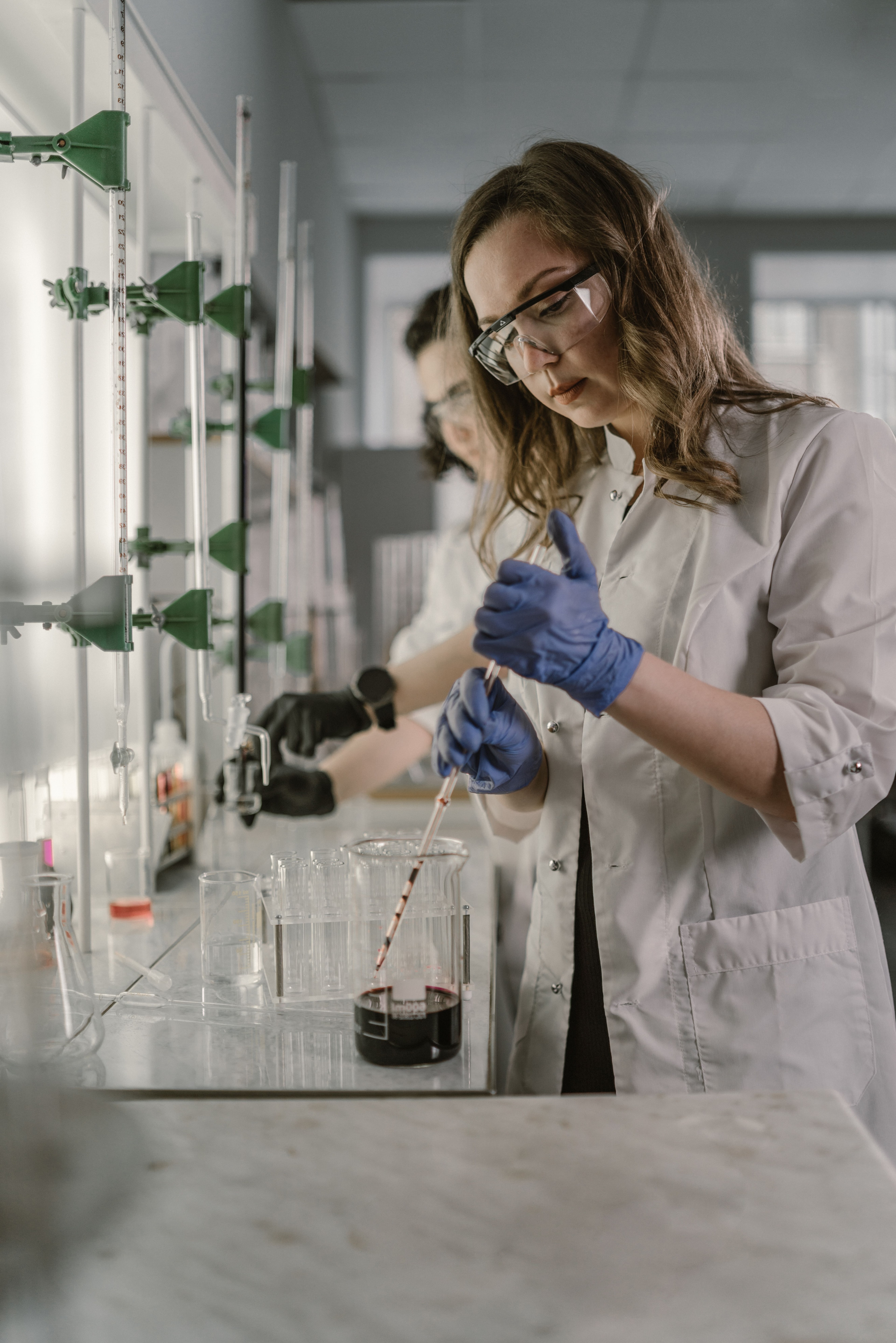 Laboratoriemedarbejder arbejder med glasudstyr og væsker.