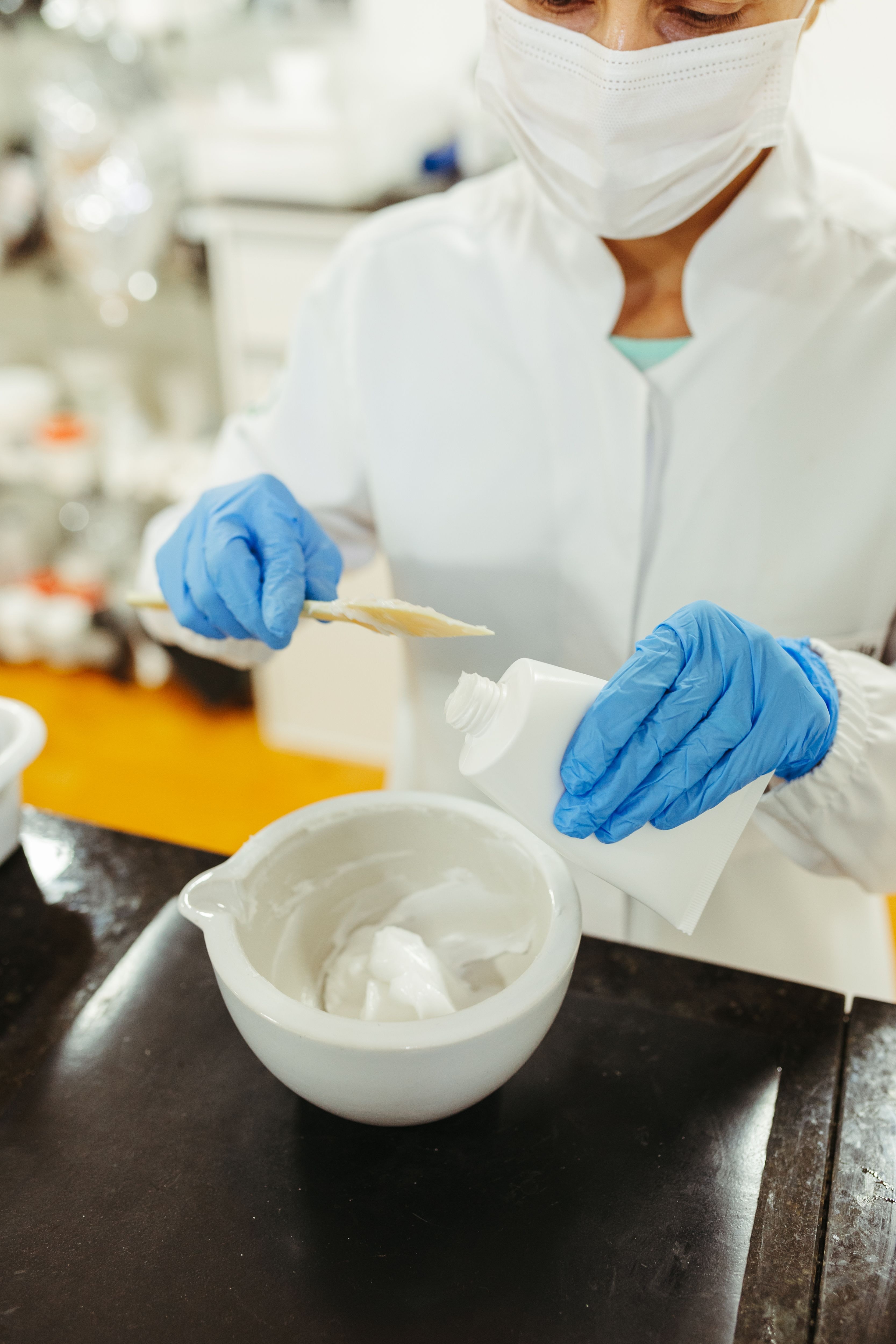 Laboratoriemedarbejder blander materiale i en skål.