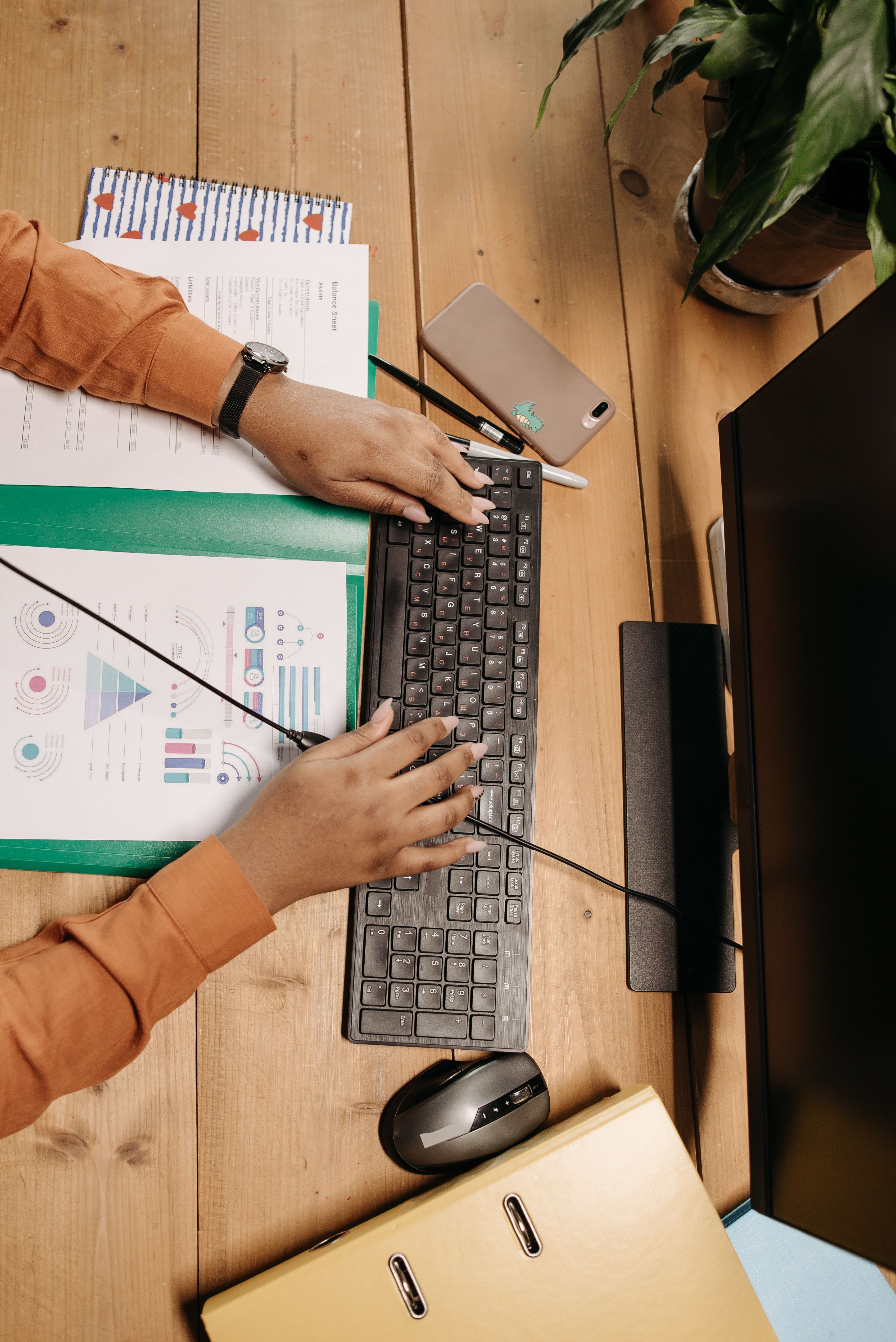 To personer arbejder ved en computer med diagrammer på bordet.