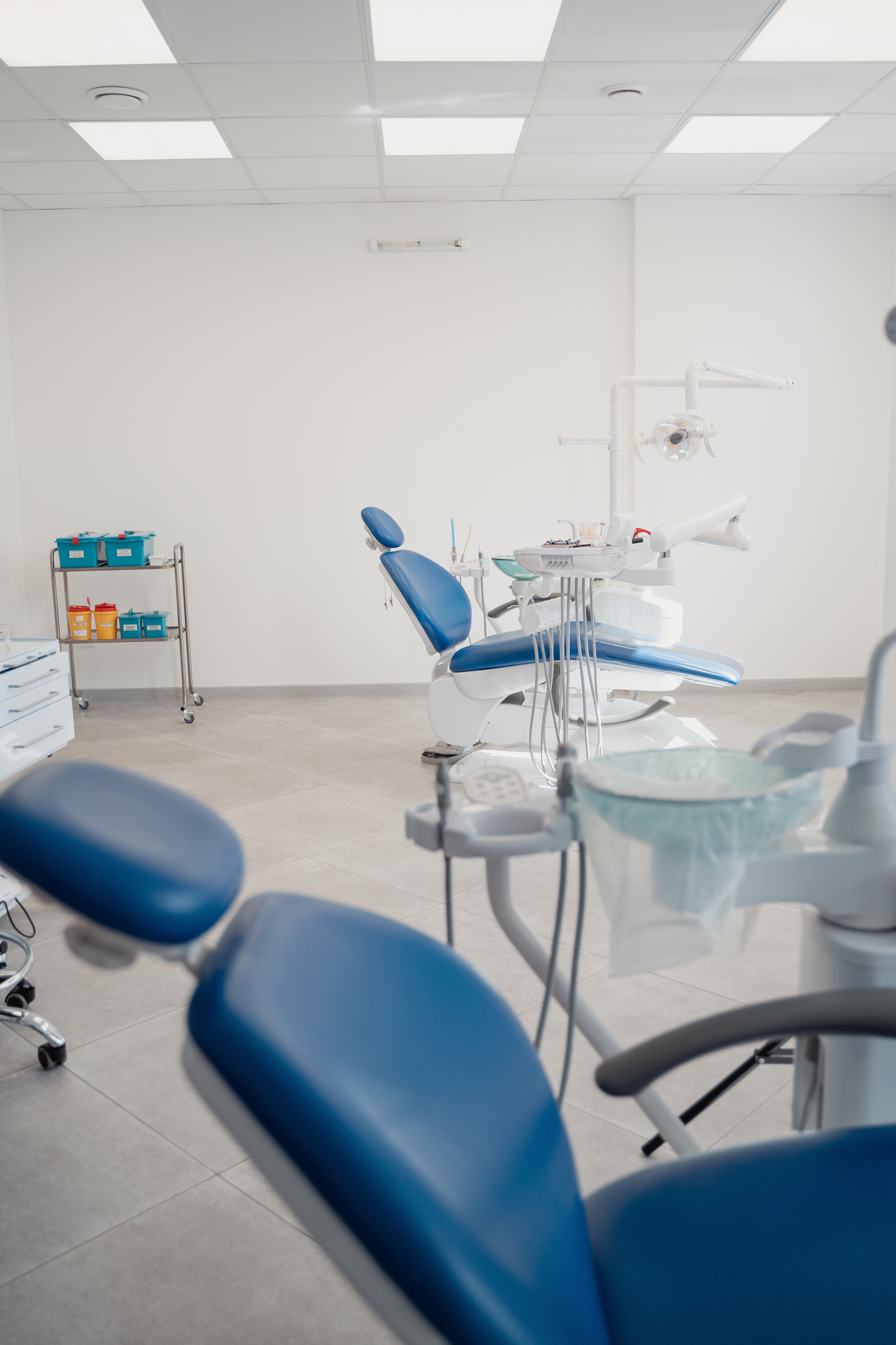 Tom behandlingsstol og klinikudstyr i et lyst rum.