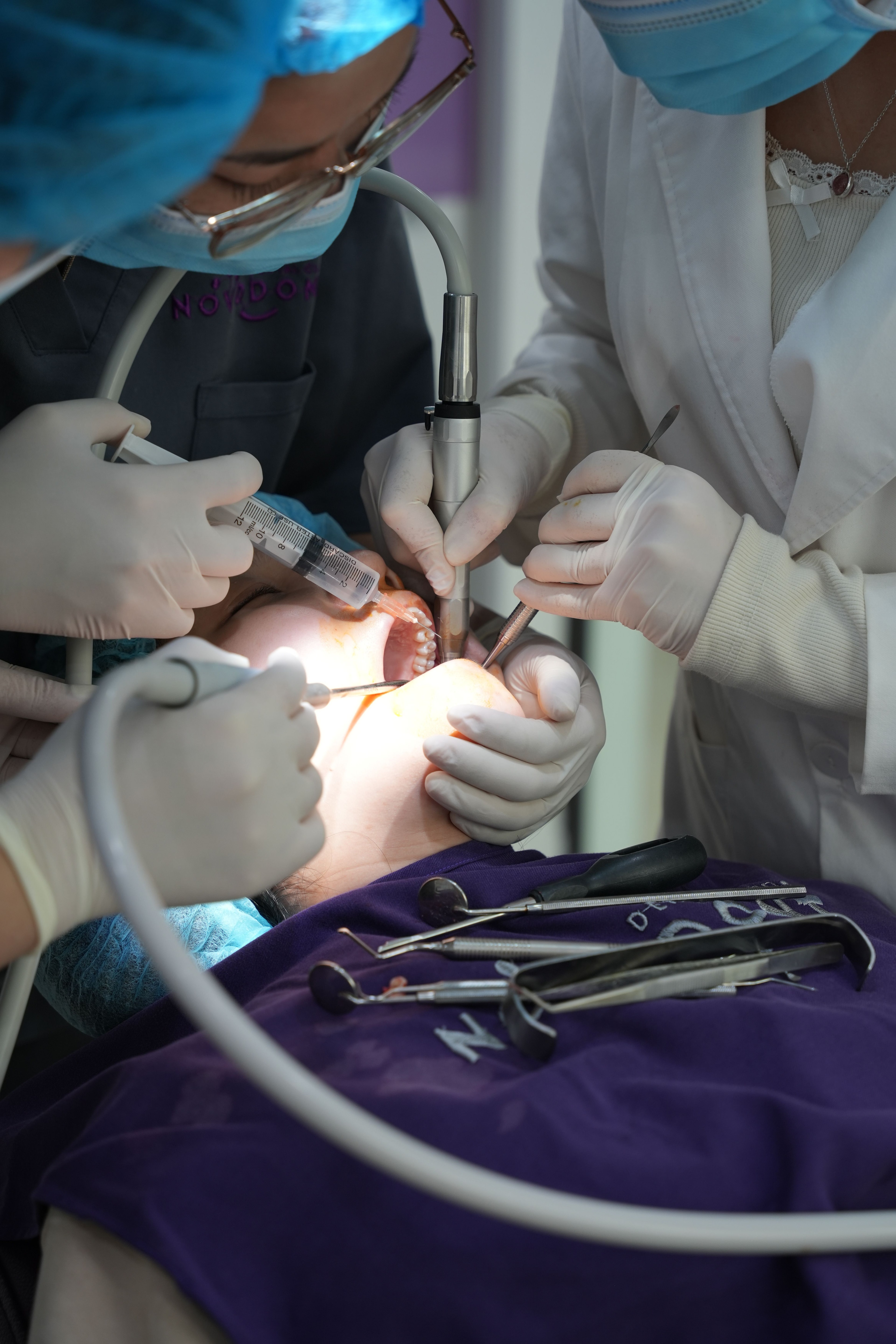 Behandlerteam arbejder ved en patients mund.
