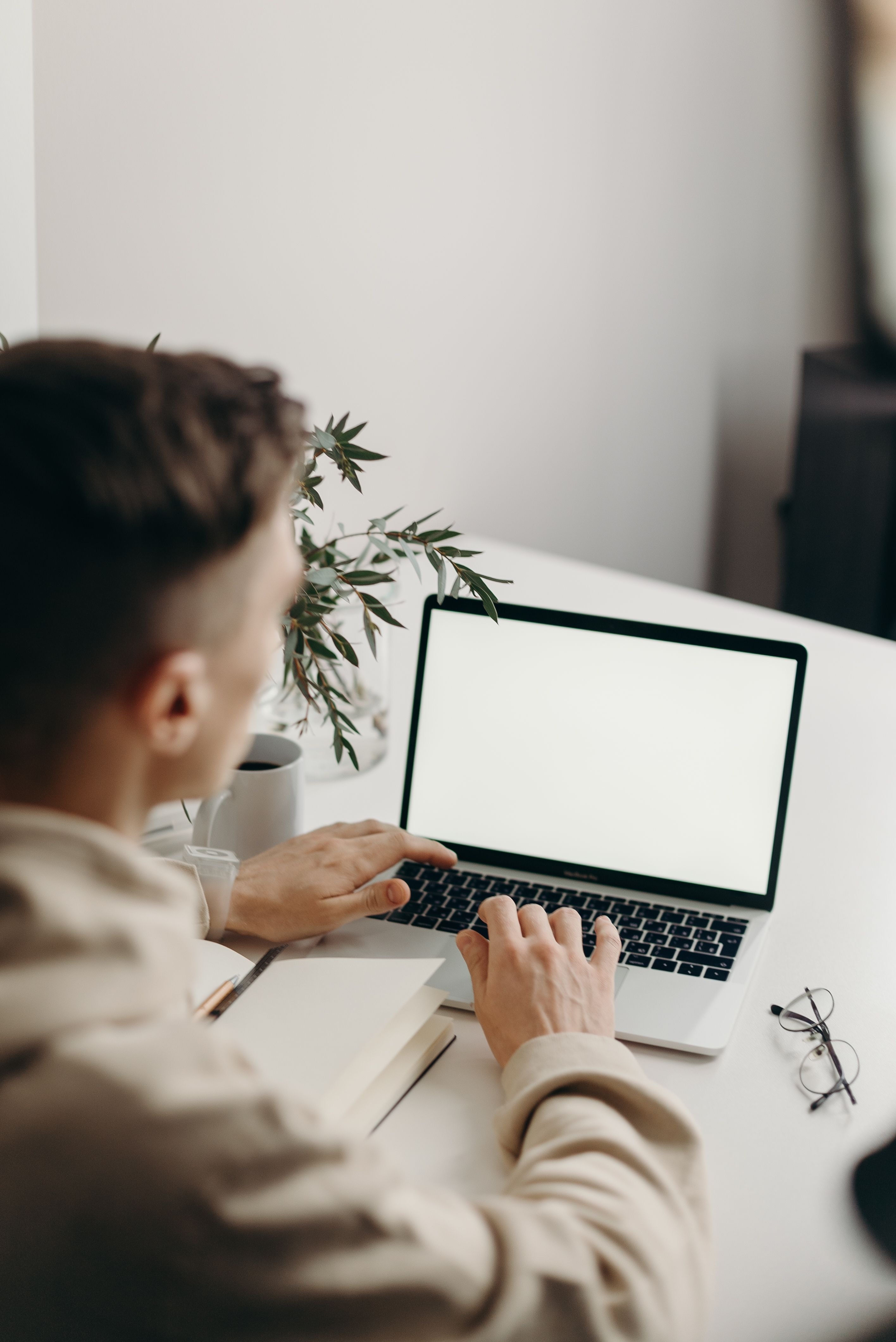 Person arbejder ved en bærbar computer med tom skærm.