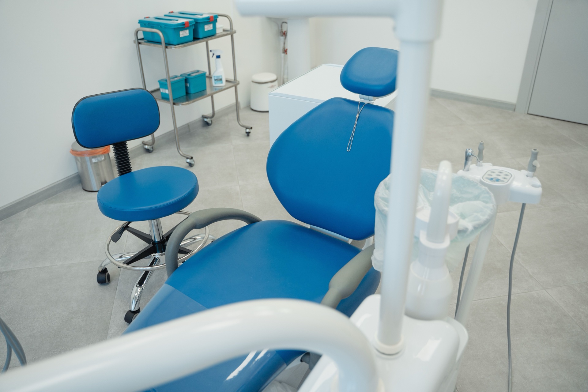 Moderne tandklinik med blå behandlingsstol og lyst klinikmiljø.
