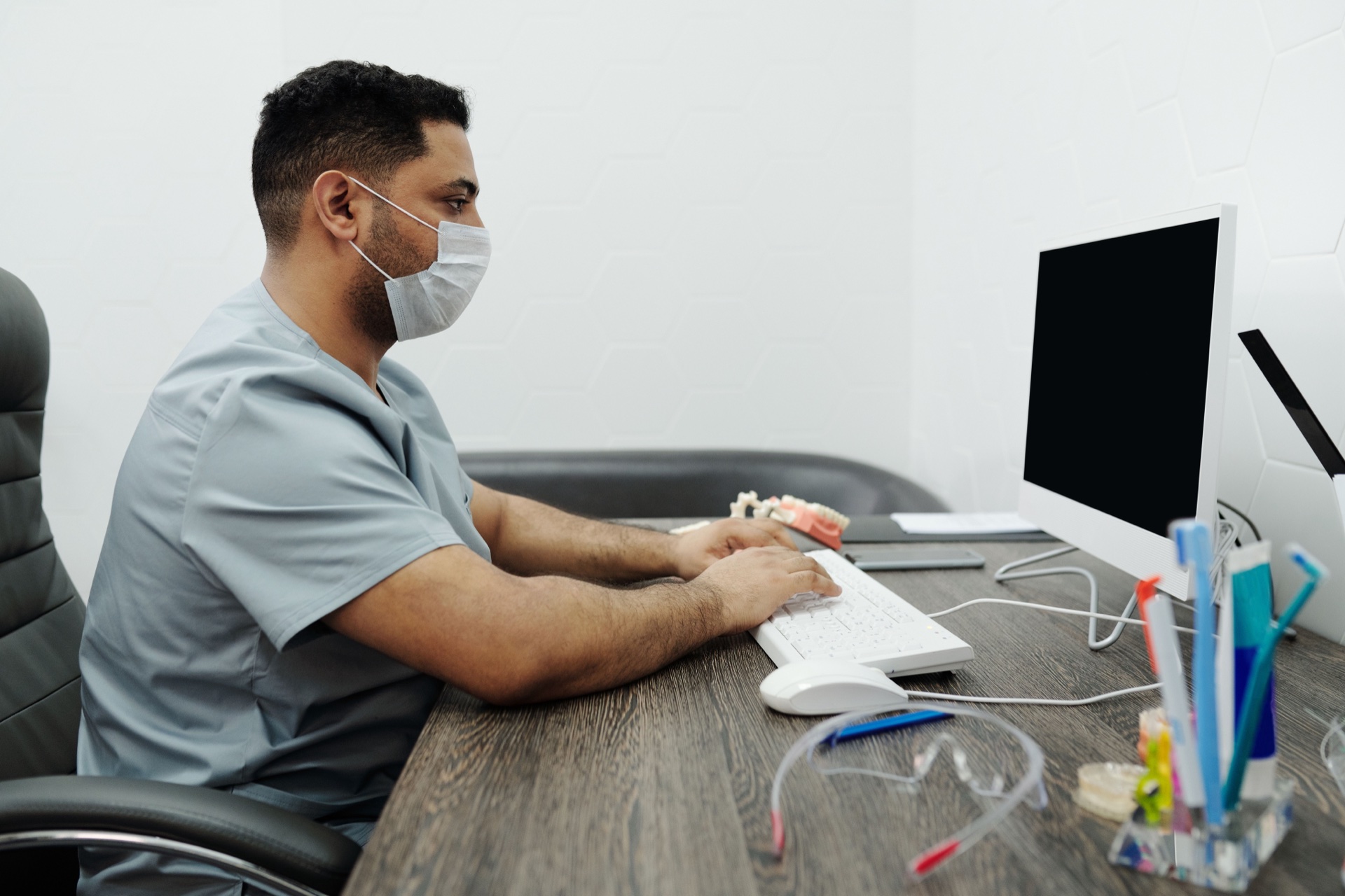 Tandlæge registrerer oplysninger ved en computer i klinikken.