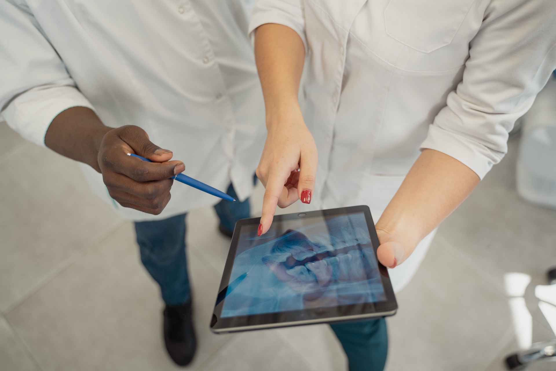To tandlægefaglige kolleger gennemgår et røntgenbillede på en tablet.